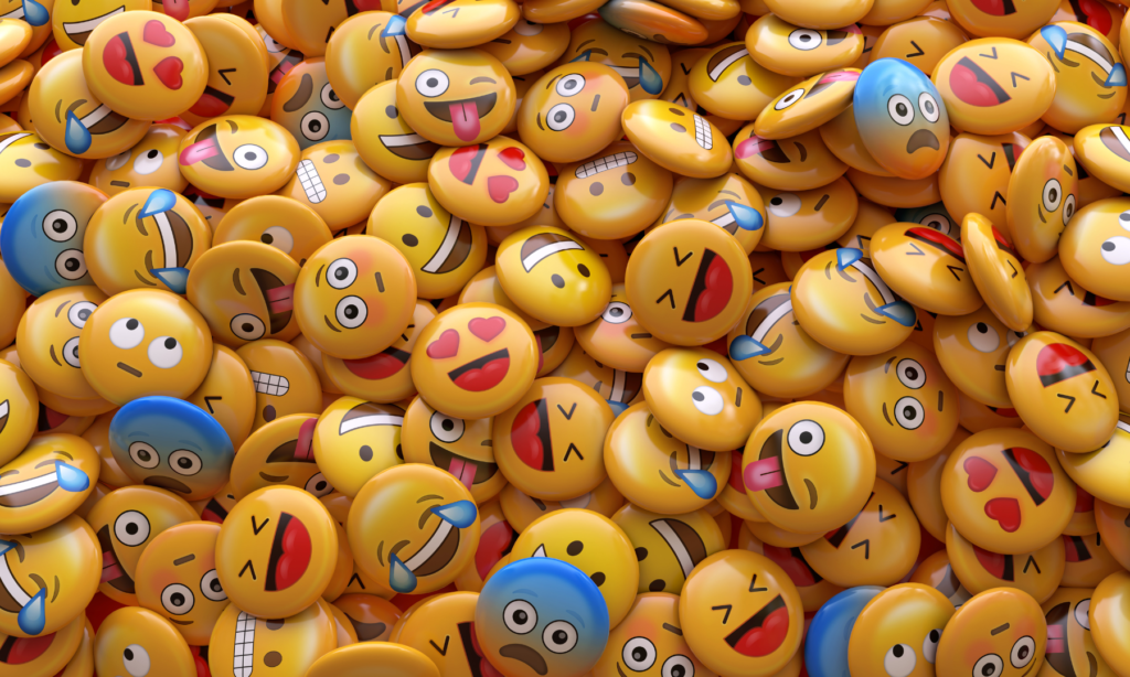 A large pile of foam emojis with all different types of emoji faces on them.