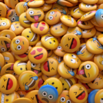 A large pile of foam emojis with all different types of emoji faces on them.